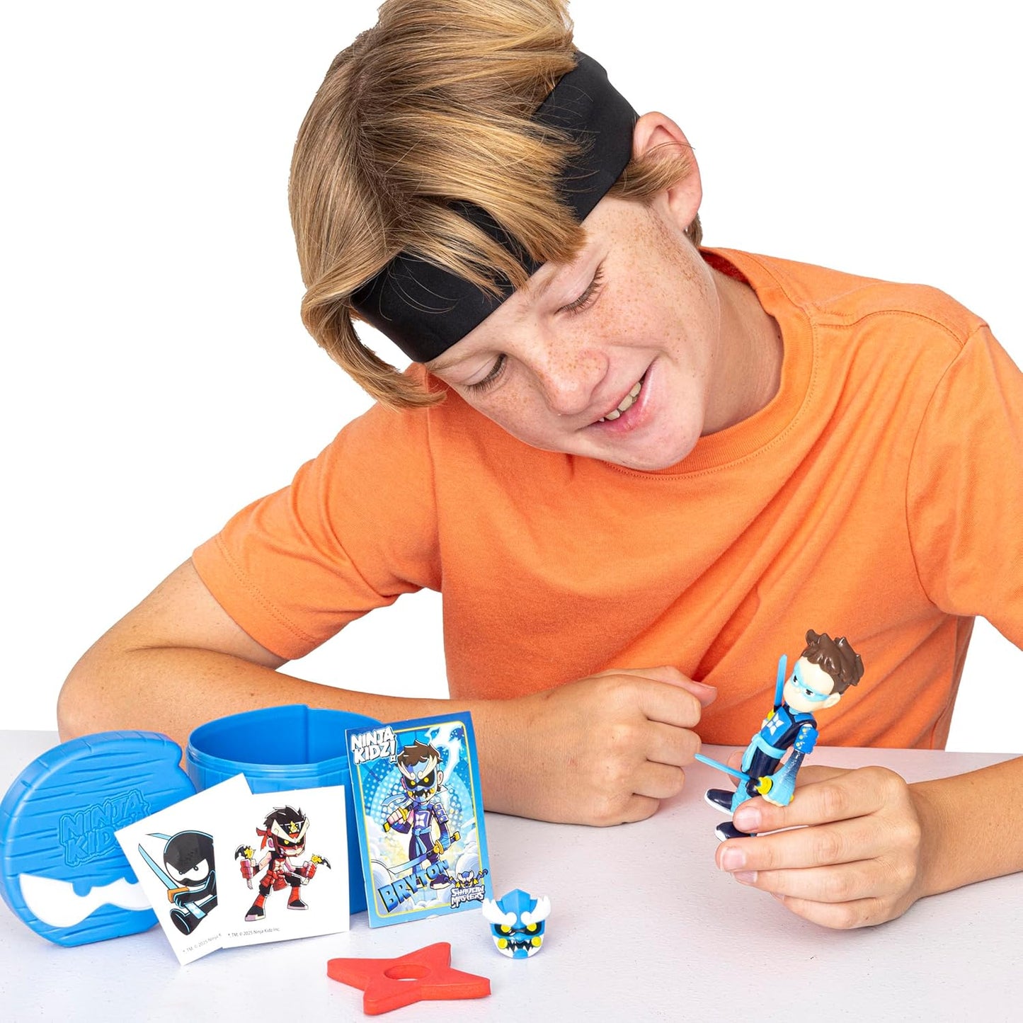 Child playing with a Ninja Kidz toy figure and accessories on a white background
