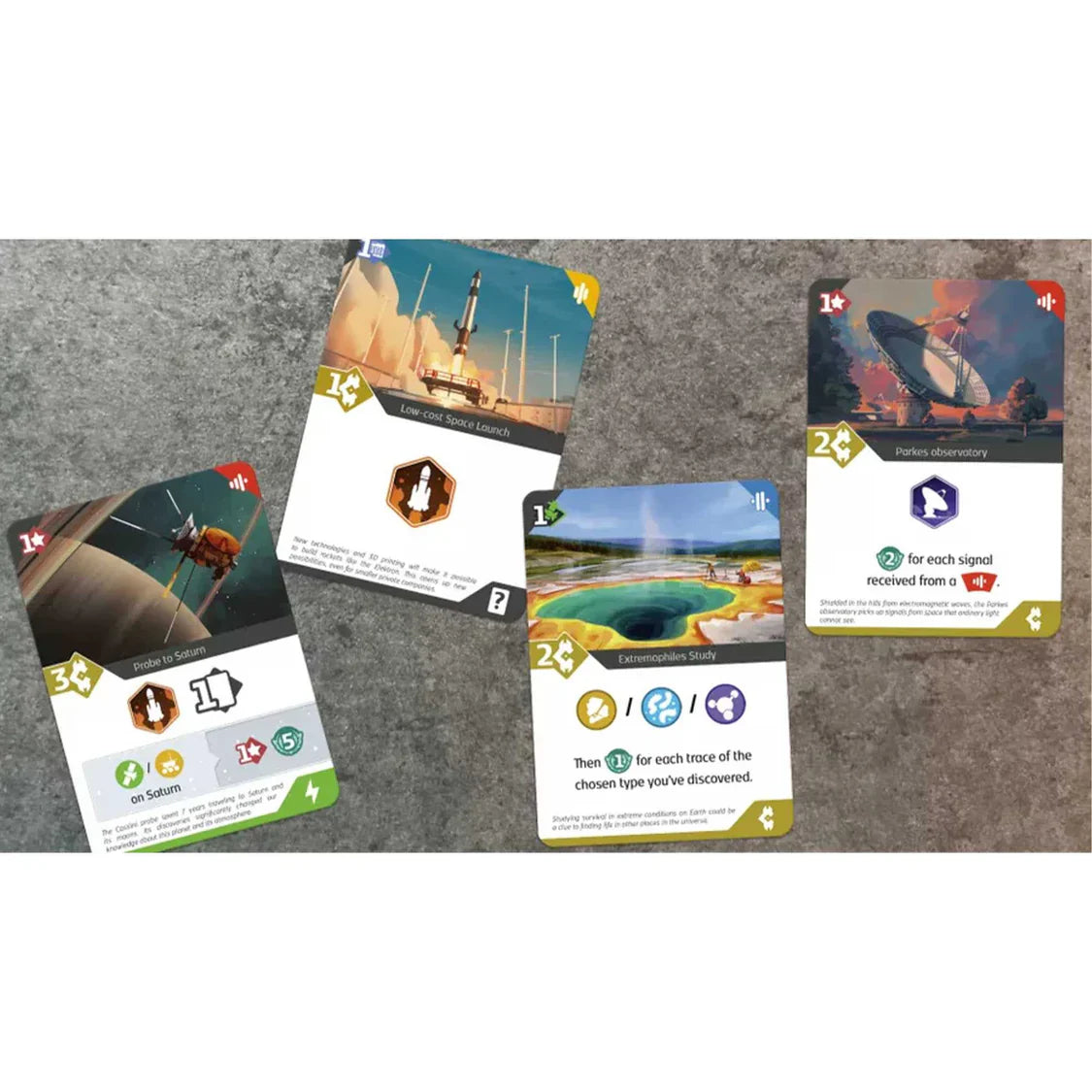 Four trading cards displayed on a textured surface