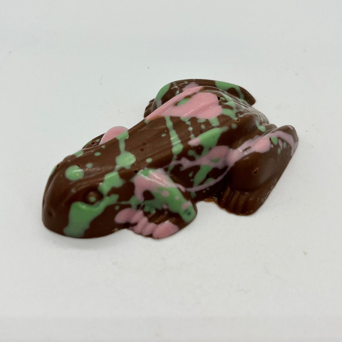 Chocolate frog with green and pink patterns on a white background