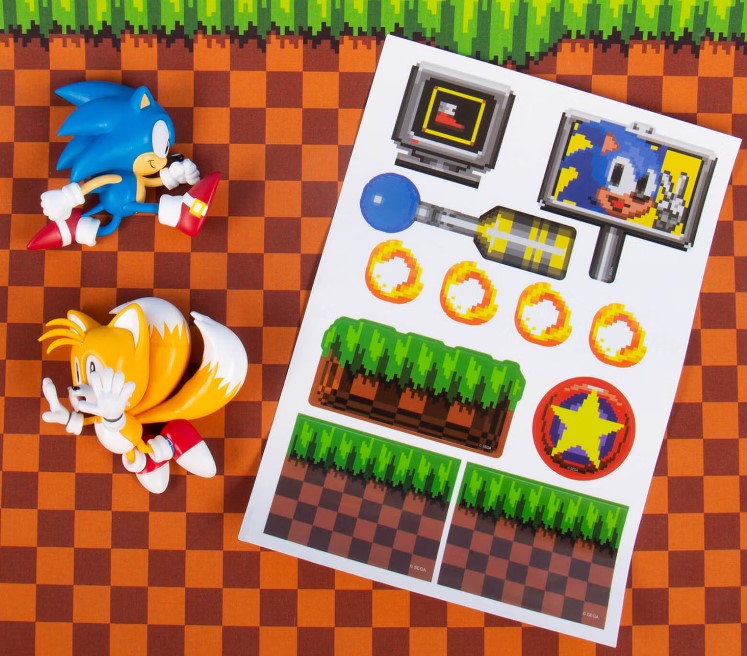 Sonic the Hedgehog toys and game console with game graphics on a checkered background