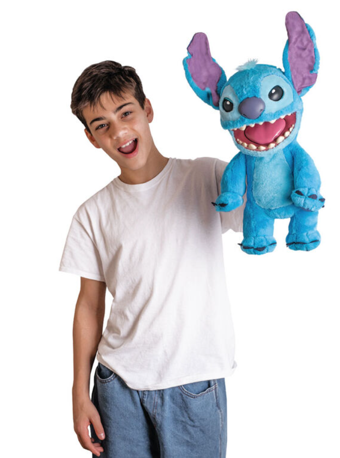 Child holding a blue plush toy resembling a cartoon character on a white background