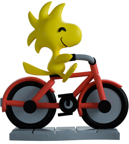 vinyl figure of Woodstock riding a bike