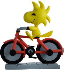 vinyl figure of Woodstock riding a bike