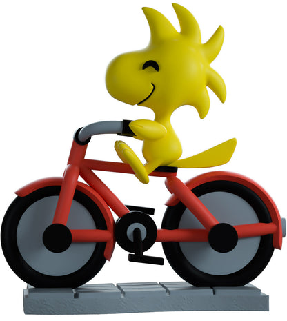vinyl figure of Woodstock riding a bike