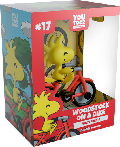 Boxed vinyl figure of Woodstock riding a bike with colorful packaging