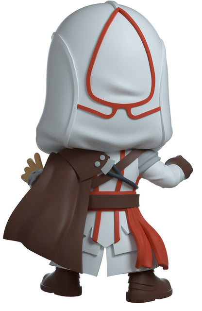Youtooz - Assassins Creed - Ezio, Figurine of a character in a white hood with red emblem, brown coat, and white pants on a white background