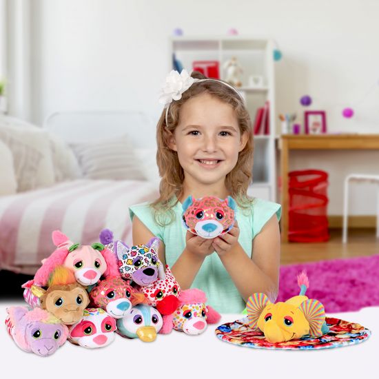 Young girl holding a plush toy in a room with colorful toys and furniture.