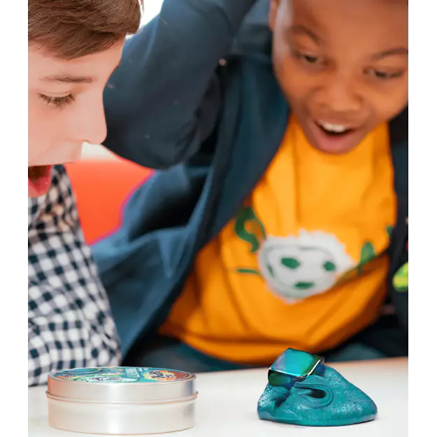 Two children playing with a blue toy putty and a small container on a white surface.
