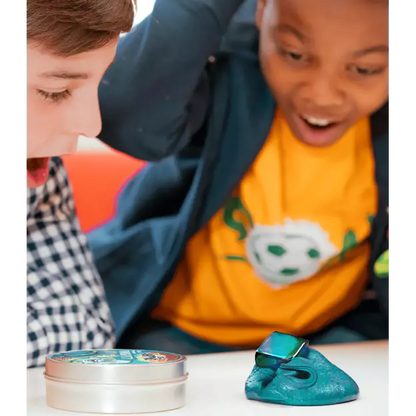 Two children playing with a blue toy putty and a small container on a white surface.