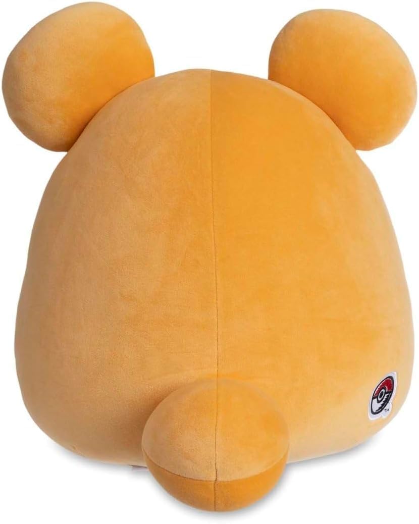 Yellow plush toy Teddiursa with round ears and a small Pokomon logo on a white background