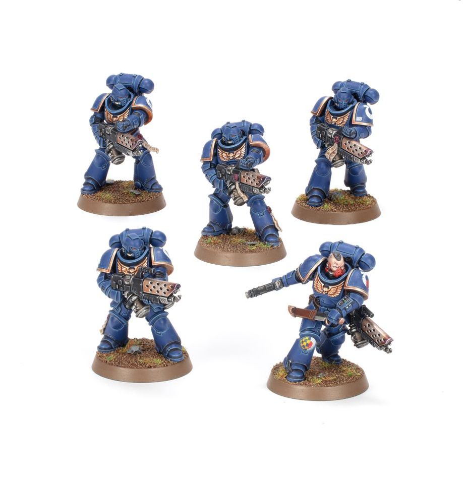 Five miniature figures in blue armor on brown bases against a white background