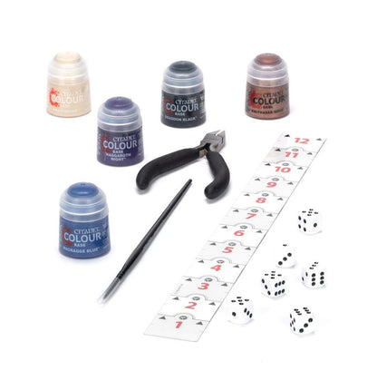 Set of Citadel Colour miniatures paint pots, a brush, pliers, and dice on a white background