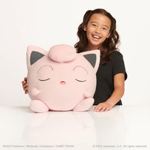Child holding a large Pokémon Jigglypuff Sleeping Plush with closed eyes on a white background