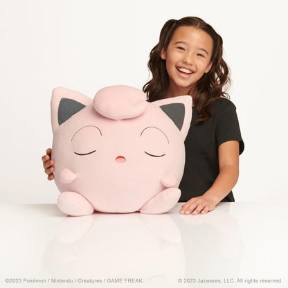 Child holding a large Pokémon Jigglypuff Sleeping Plush with closed eyes on a white background