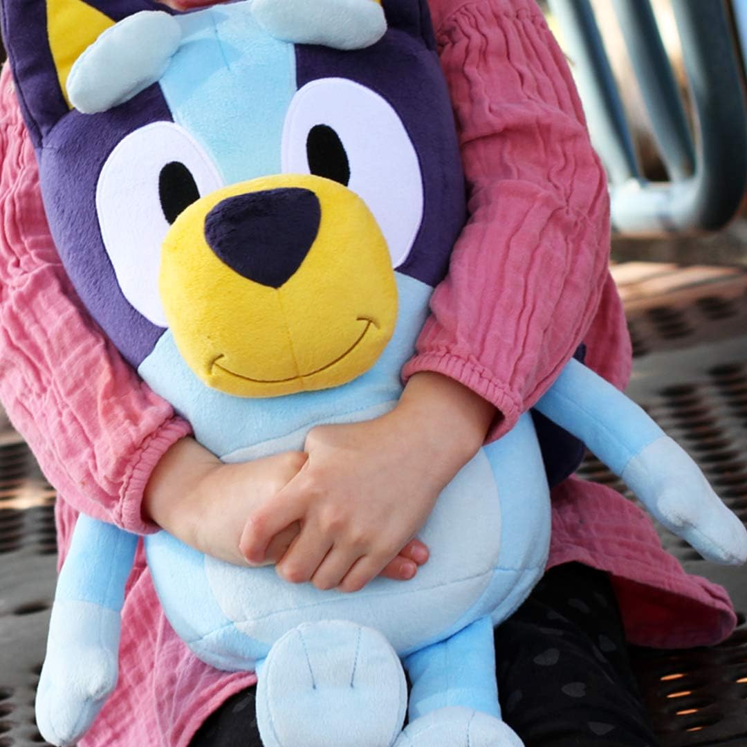 Child holding a large Bluey plush toy