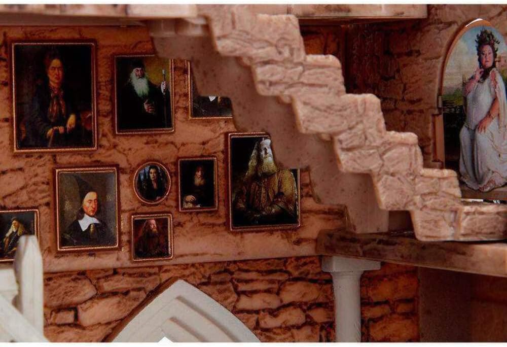 Staircase with stone walls and framed portraits on a stone wall.