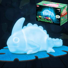 Colour-changing chameleon toy with glowing effect on a dark background