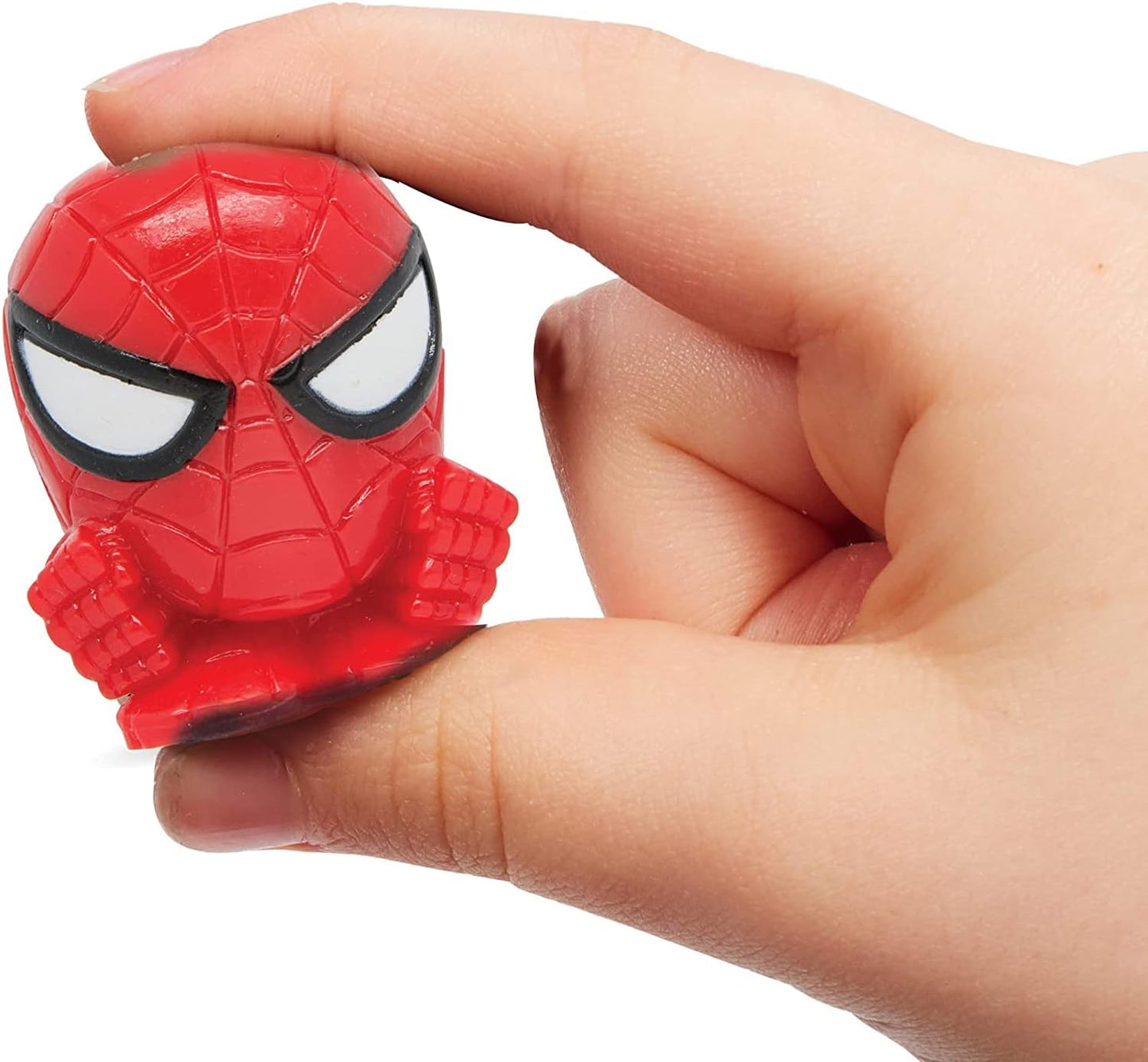 Hand holding a red superhero figurine with a white background