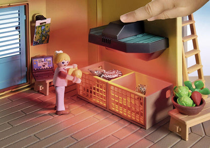Toy kitchen set with a toy character, cabinets, and a hand holding a toy vacuum cleaner.
