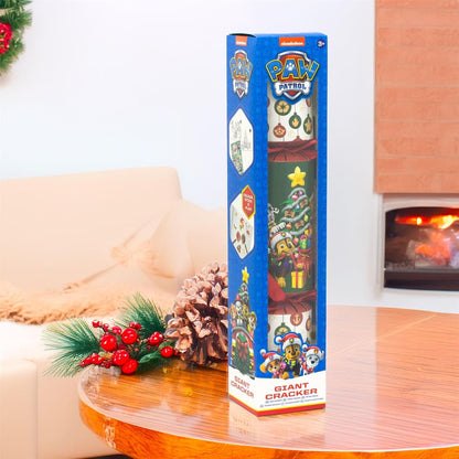 PAW Patrol Giant Cracker box on a table with festive decorations and a fireplace in the background