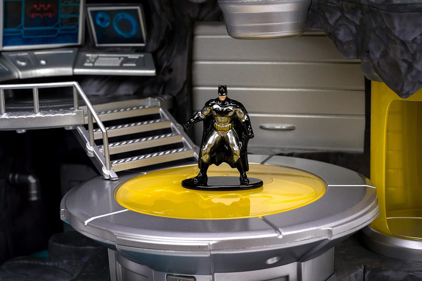 Batman figurine on a yellow and gray platform with a futuristic setting