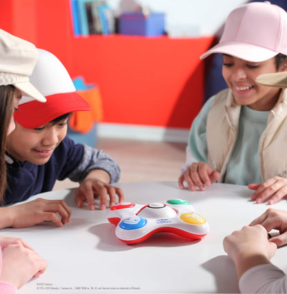Children playing with a toy on a table in a classroom setting