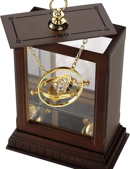Gold Time Turner mechanism in a wooden display case on a white background