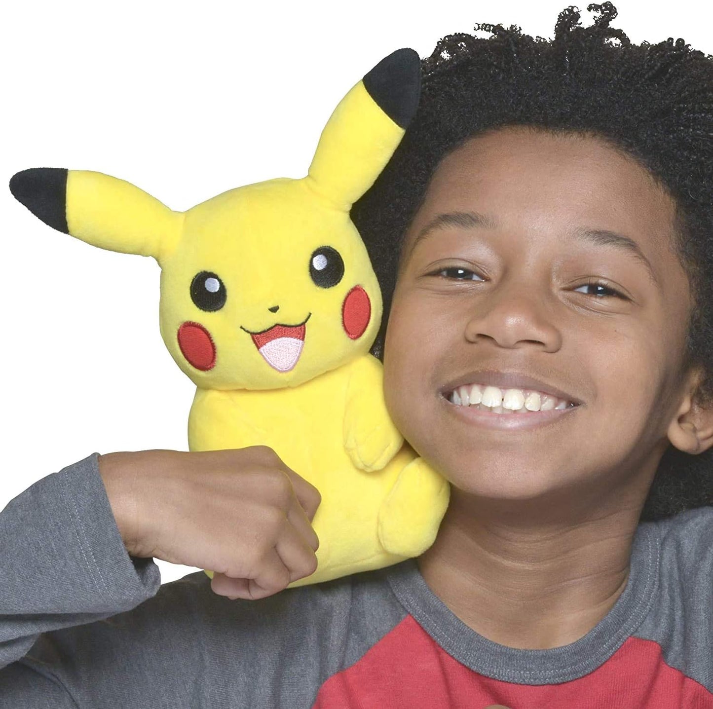 Child holding a Pikachu plush toy against a white background