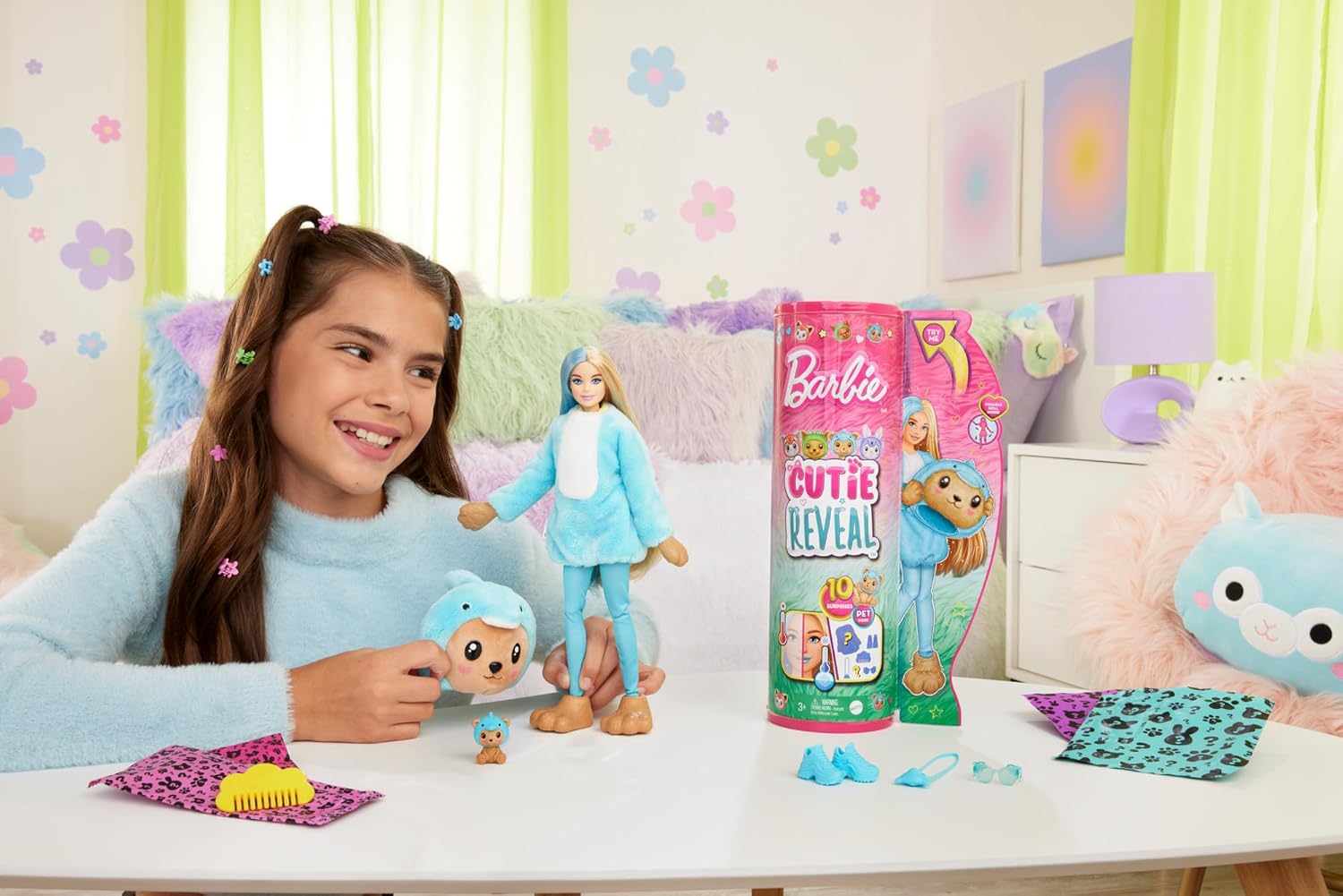 Girl playing with a toy set on a table, with a Barbie Cutie Reveal box in the background.