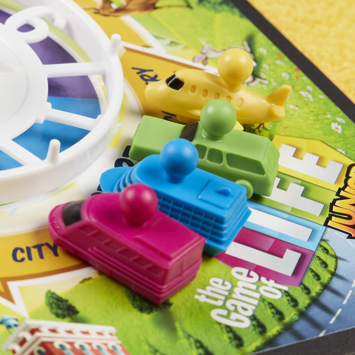Colorful toy vehicles on a board game with 'The Game of Life' text