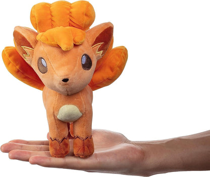 Pokémon Vulpix plush toy held in a hand against a white background