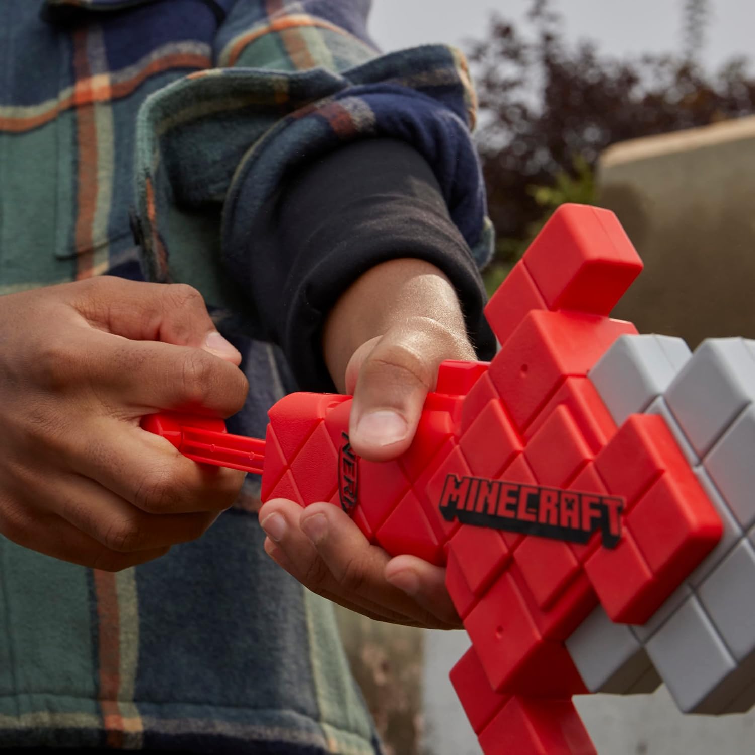 Person holding a red and gray Minecraft-themed toy sword.