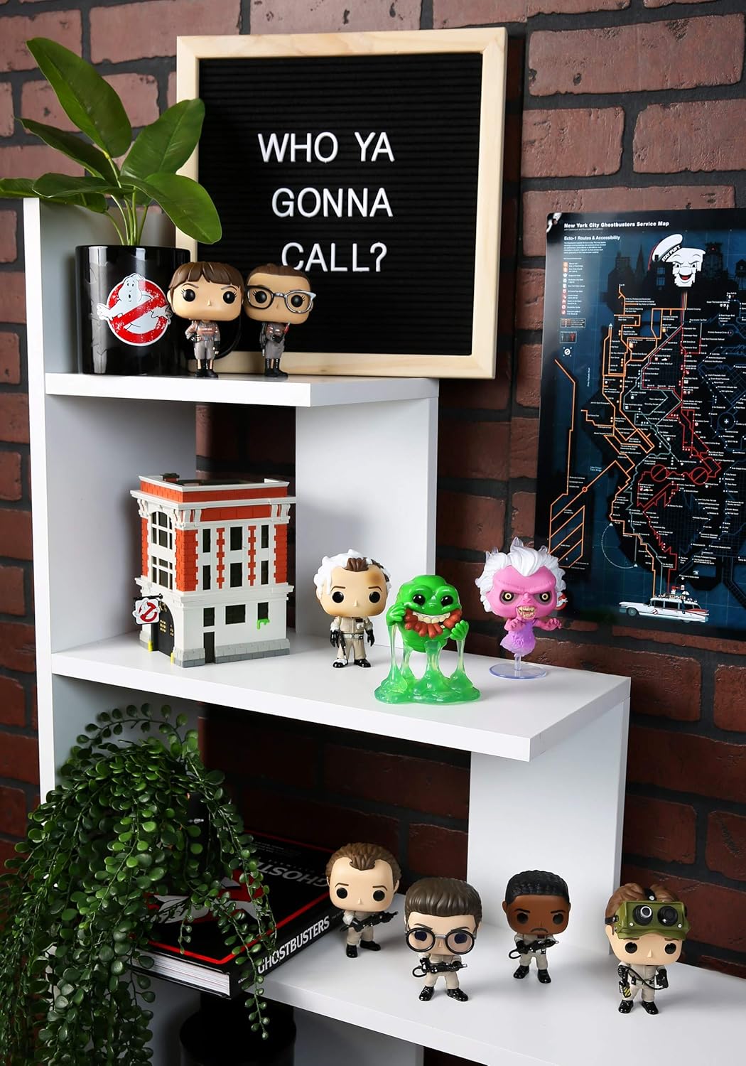 White shelf with Funko Pop! figures and a letterboard against a brick wall.