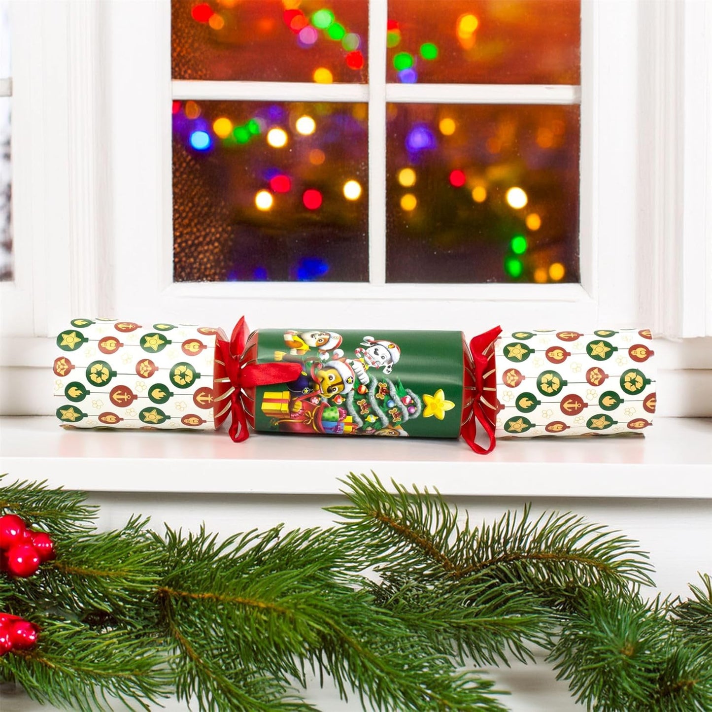 Christmas cracker with festive design in front of a window with blurred lights