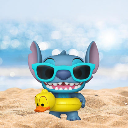 Toy figure of a character Stitch with sunglasses and a rubber duck on a beach