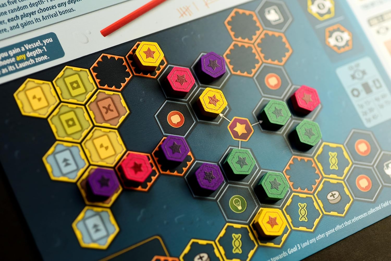 Hexagonal game pieces on a board game with colorful labels