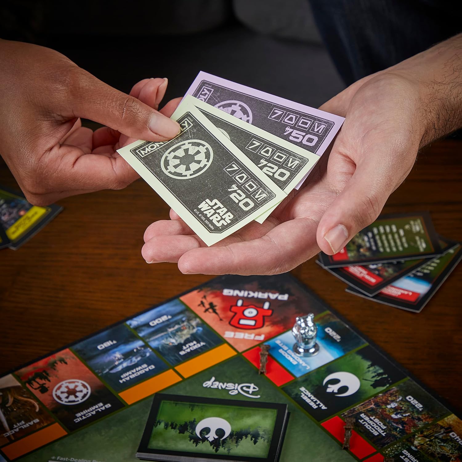 Hands holding Monopoly property cards with a game board in the background