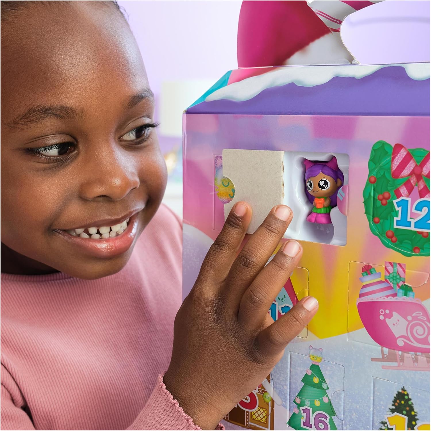 Child opening a colorful toy box with a figurine inside, surrounded by festive decorations.