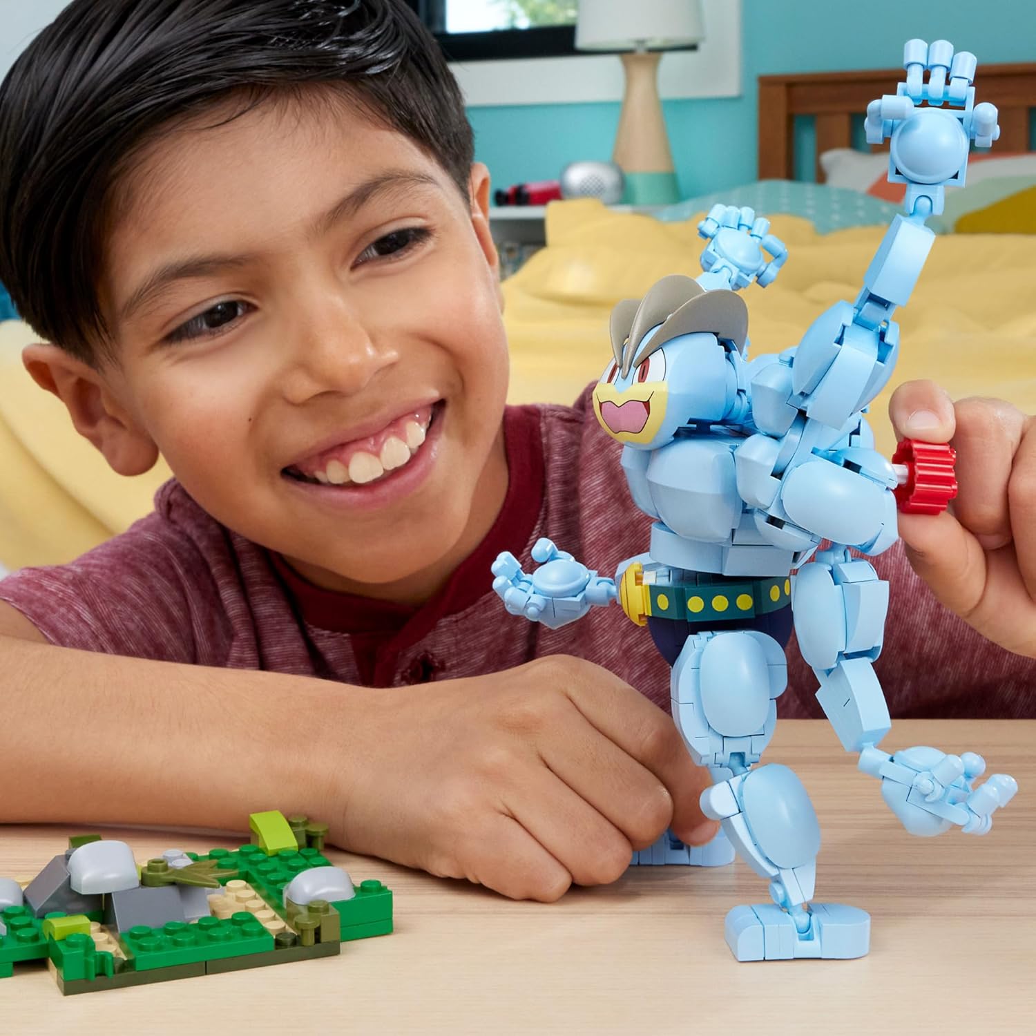 Child playing with a blue robot toy on a table