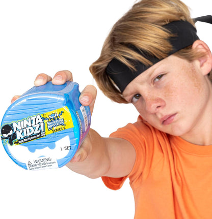 Child holding a blue 'Ninja Kidz!' toy packaging with a white background