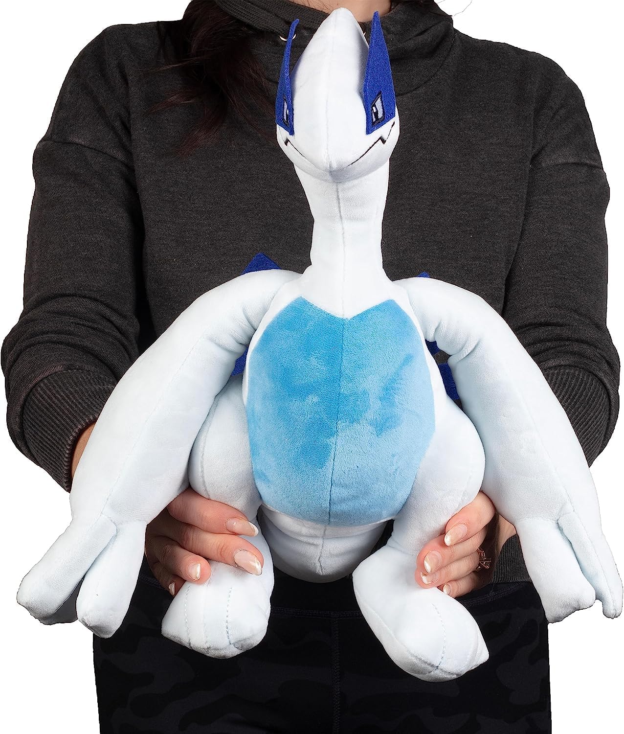Person holding a large white and blue plush toy with blue accents
