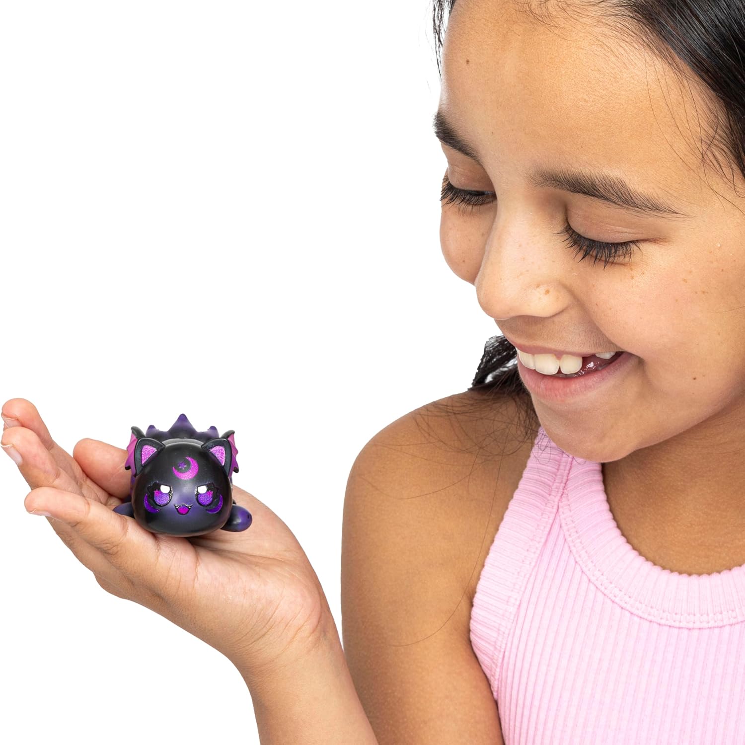 Young girl holding a small purple and black Aphmau toy with a white background