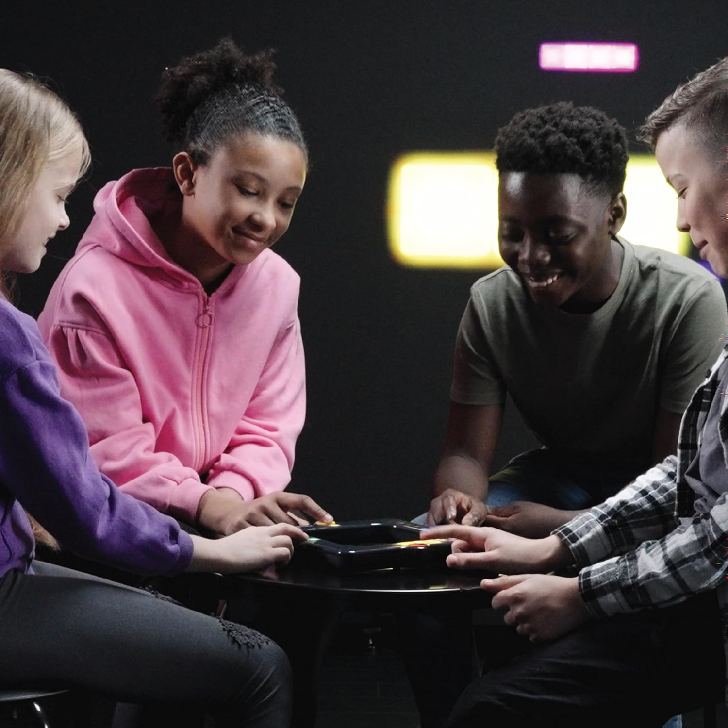 Four children sitting around a table, engaged in playing snake attack.