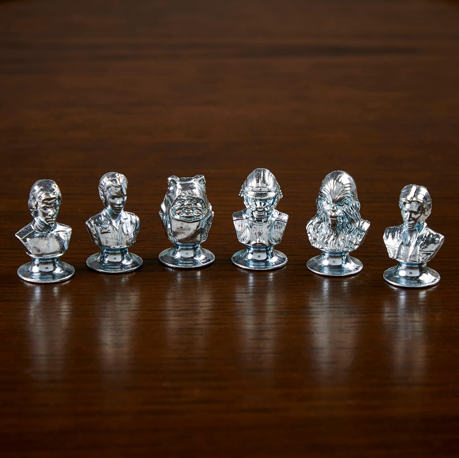 Set of six busts for playing monopoly on a wooden surface