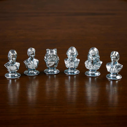 Set of six busts for playing monopoly on a wooden surface