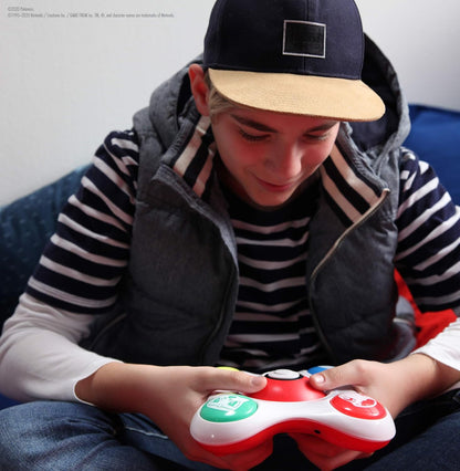 Person wearing a cap and striped shirt, holding a red and white toy device.