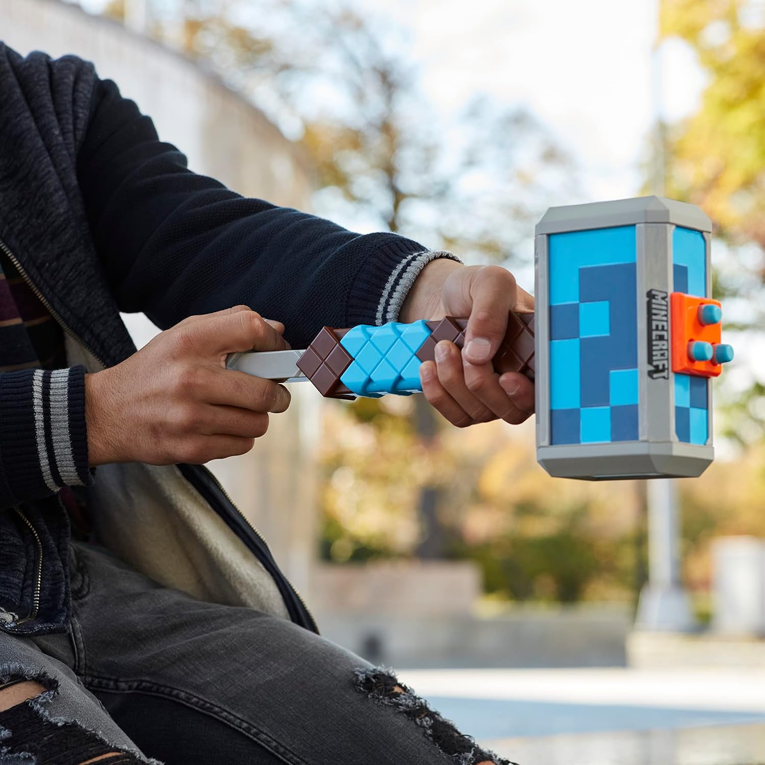 Two hands holding pixelated sword and shield against a blurred outdoor background