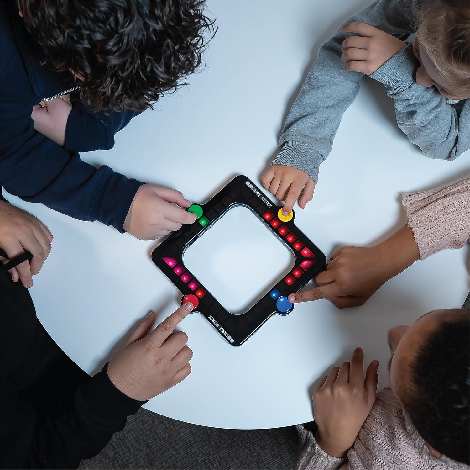 Children playing with a light-up board game on a white table