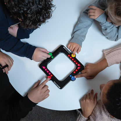 Children playing with a light-up board game on a white table