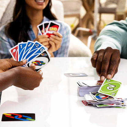 Two people playing cards at a table with colorful cards.